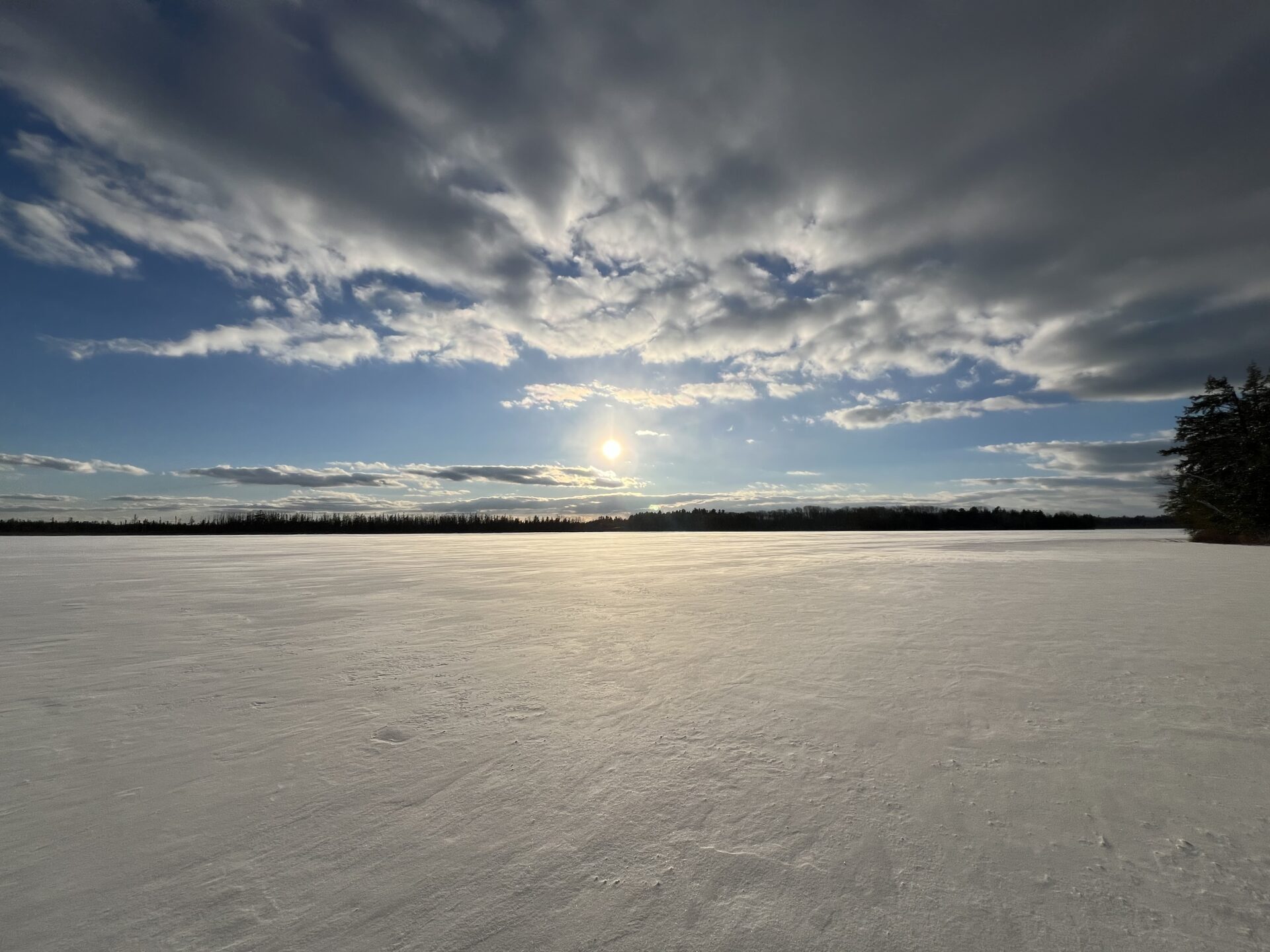 picture of the sun over a frozen lake