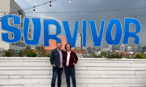 photo of my dad and I standing on a deck with a giant survivor sign behind us