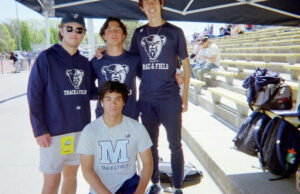 Photo of me with 3 UMaine track runners at a meet