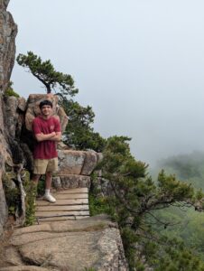 Saurav standing on one of the thin bridges between a gap in the rocks