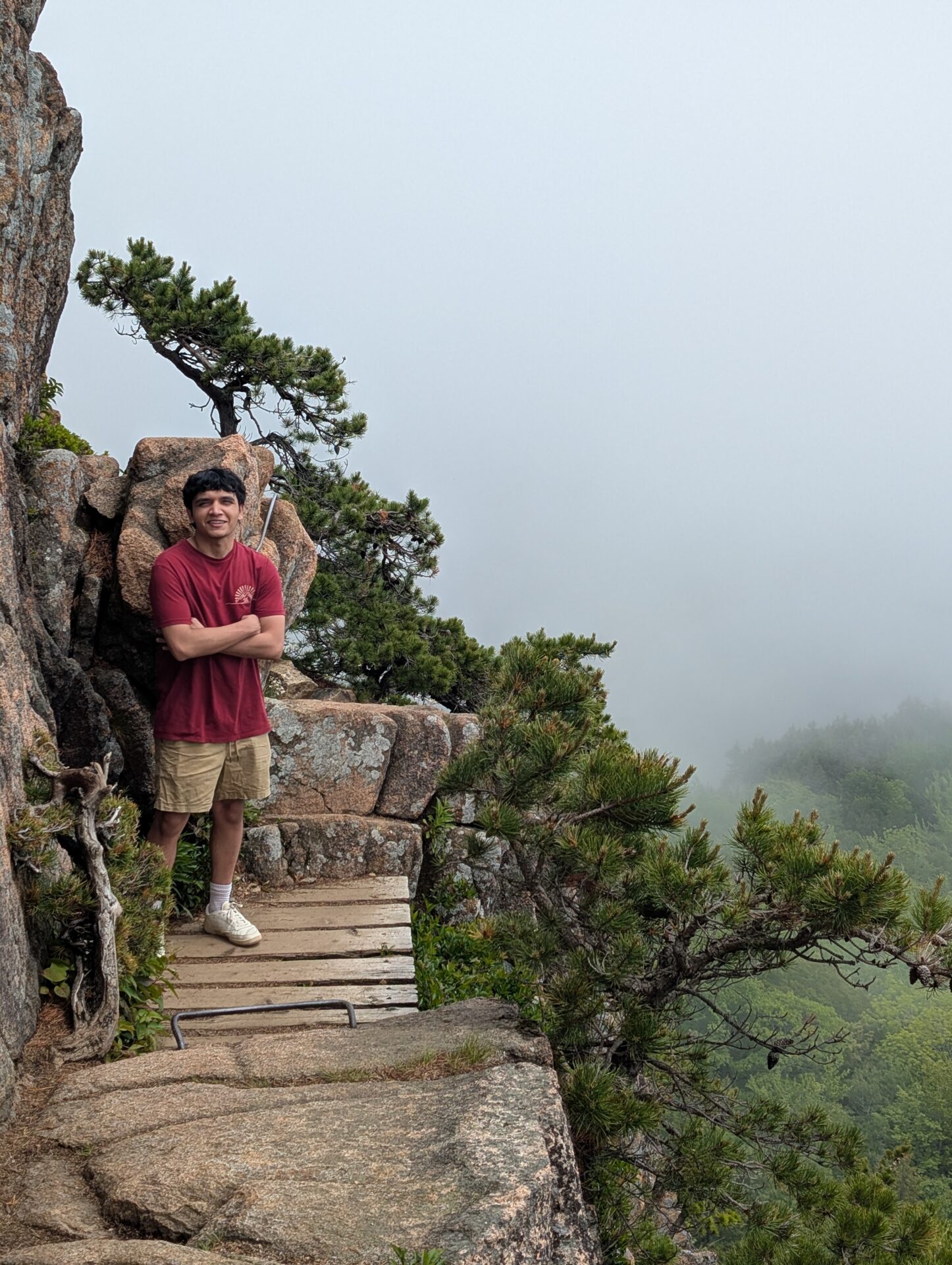 Saurav standing on one of the thin bridges between a gap in the rocks