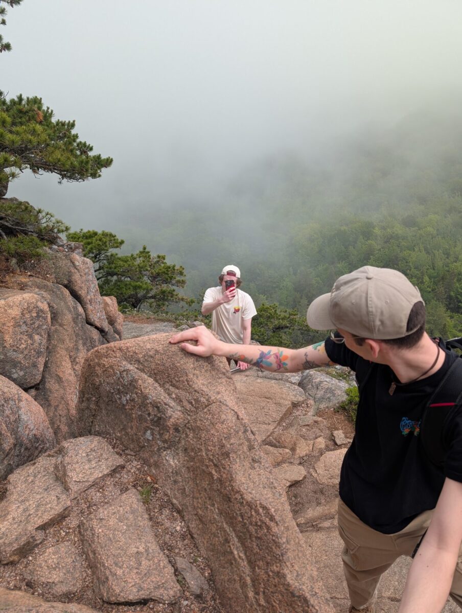 Walker taking a picture of me and Harrison climbing up the rocks