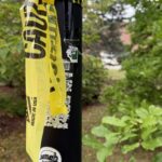advertisements on a pole covered by caution tape