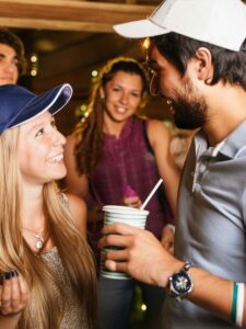 Firefly a man talking to a girl at a college houseparty. Intense Party- informal college clothing, b
